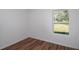Bedroom with wood-look floors, white walls, and a window at 16615 Se 63Rd Ln, Ocklawaha, FL 32179