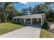 Charming single-story home with a light gray exterior, covered carport, and a well-manicured lawn at 16615 Se 63Rd Ln, Ocklawaha, FL 32179