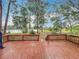 A spacious backyard view from the deck, showcasing mature trees and a covered structure at 16621 Se 57Th Pl, Ocklawaha, FL 32179