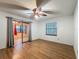 Bedroom features wood floors, a ceiling fan, a sliding glass door and a window at 16621 Se 57Th Pl, Ocklawaha, FL 32179