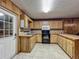 Galley kitchen featuring wood paneling, tile floors, and cabinetry with modern appliances at 16621 Se 57Th Pl, Ocklawaha, FL 32179