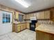 Well-organized kitchen with wooden cabinets, a microwave, and tiled flooring, providing a practical cooking environment at 16621 Se 57Th Pl, Ocklawaha, FL 32179
