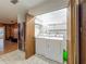 Laundry closet with white washer and dryer, wire shelving, and tile floors next to a stainless fridge at 16621 Se 57Th Pl, Ocklawaha, FL 32179