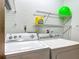 A well-equipped laundry area with a washer and dryer set, complemented by shelving for storage at 16621 Se 57Th Pl, Ocklawaha, FL 32179