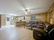 Cozy living room featuring wood paneling, a ceiling fan, laminate flooring, and a comfortable leather sectional sofa at 16621 Se 57Th Pl, Ocklawaha, FL 32179