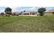 Large grassy backyard with a screened-in enclosure attached to the back of the house at 2002 Enrique Dr, Lady Lake, FL 32159