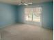 Tranquil bedroom featuring serene blue walls, ceiling fan and a large window at 2002 Enrique Dr, Lady Lake, FL 32159
