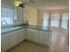 Bright kitchen features tile flooring, white cabinets and appliances, and an eat-in breakfast nook at 2002 Enrique Dr, Lady Lake, FL 32159