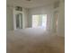 Open-concept living room with multiple entryways showing spacious layout with neutral carpet and light walls at 2002 Enrique Dr, The Villages, FL 32159