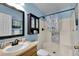 Cozy bathroom featuring a shower, vanity with sink, and framed mirror with a stylish nautical themed shower curtain at 2263 Moines Ct, Dunnellon, FL 34431