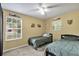 Bedroom showcasing two twin beds, natural light from windows, and beige-toned walls at 2263 Moines Ct, Dunnellon, FL 34431