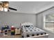 Comfortable bedroom featuring a bed, ceiling fan, and natural light streaming in from a large window at 2263 Moines Ct, Dunnellon, FL 34431