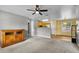 Cozy living room with grey walls, carpet, ceiling fan and open access to the kitchen at 2263 Moines Ct, Dunnellon, FL 34431
