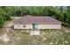 Aerial rear exterior showcasing patio, yard, and trees, featuring a sliding glass door at 23340 Nw Columbine Ave, Dunnellon, FL 34431