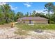 View of the home's rear exterior, featuring a sliding glass door and lots of trees at 23340 Nw Columbine Ave, Dunnellon, FL 34431
