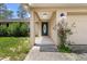 Covered front door with decorative window and concrete walkway leading to the driveway at 23340 Nw Columbine Ave, Dunnellon, FL 34431