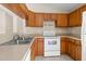 Well-lit kitchen with wood cabinets, stainless steel sink, and modern appliances for a chef-inspired cooking space at 23340 Nw Columbine Ave, Dunnellon, FL 34431