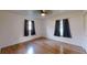 Bedroom with hardwood floors, two windows, and curtains at 2441 Se 38Th St, Ocala, FL 34480