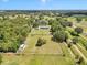 Expansive aerial view of a private estate, showcasing the home, surrounding trees, and open land at 300 Se Highway 42, Summerfield, FL 34491