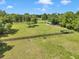 Expansive fenced backyard featuring lush green grass and mature trees, perfect for outdoor activities and enjoying nature at 300 Se Highway 42, Summerfield, FL 34491