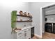 Stylish bar area with custom shelving, mini fridge, and direct access to the laundry room at 300 Se Highway 42, Summerfield, FL 34491