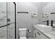 Modern bathroom with marble vanity, black hardware and faucets, and a frameless shower at 300 Se Highway 42, Summerfield, FL 34491
