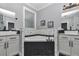 Elegant bathroom featuring double vanities, a soaking tub, and modern fixtures with black and white mosaic tile accents at 300 Se Highway 42, Summerfield, FL 34491