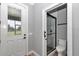 Neutral bathroom featuring a toilet, frameless shower with glass doors, and a backyard view from the window at 300 Se Highway 42, Summerfield, FL 34491