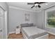 Cozy bedroom with a queen-sized platform bed, ceiling fan, and a window with natural light at 300 Se Highway 42, Summerfield, FL 34491