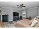 Bedroom featuring wood-look floors, an upholstered bed, a ceiling fan and an area rug at 300 Se Highway 42, Summerfield, FL 34491