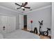 Bedroom setup with wood-look floors, a spin bike, free weights, and a ceiling fan at 300 Se Highway 42, Summerfield, FL 34491