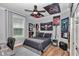 A bedroom decorated with posters and flags, features wood-look floors, fan, and a black bedspread at 300 Se Highway 42, Summerfield, FL 34491