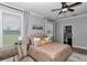This bedroom has an upholstered bed, wood-look floors, ceiling fan, and an ensuite bathroom at 300 Se Highway 42, Summerfield, FL 34491