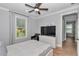 Bright bedroom with a bed, fan, dresser and chair, with large windows offering views of the outdoors at 300 Se Highway 42, Summerfield, FL 34491