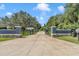 Long driveway leading to a secluded property with a gated entrance and mature trees lining the way at 300 Se Highway 42, Summerfield, FL 34491