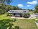 Charming single-story home with a well-manicured lawn, mature trees, and a welcoming front porch at 300 Se Highway 42, Summerfield, FL 34491