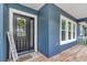 Stylish front door with a welcome sign and a decorative wreath, complemented by an inviting porch and windows at 300 Se Highway 42, Summerfield, FL 34491