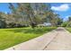 Long driveway to single-story house with mature trees and well-maintained lawn at 300 Se Highway 42, Summerfield, FL 34491