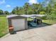 Garage and carport with parking for multiple vehicles on a concrete pad next to the main structure at 300 Se Highway 42, Summerfield, FL 34491