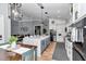 Open-concept kitchen with an island, gray lower cabinets, stainless appliances, and a dining area at 300 Se Highway 42, Summerfield, FL 34491
