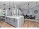 Open-concept kitchen with a large island, dining area, and modern lighting fixtures at 300 Se Highway 42, Summerfield, FL 34491