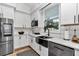 Bright kitchen with white cabinetry, subway tile, and stainless steel appliances at 300 Se Highway 42, Summerfield, FL 34491