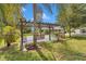 Inviting pergola with swing seating and decorative potted plants in a beautifully landscaped yard on a sunny day at 300 Se Highway 42, Summerfield, FL 34491