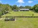 Large backyard with a well-kept lawn, garden, and a dark fenced perimeter on the property at 300 Se Highway 42, Summerfield, FL 34491