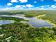 An aerial view shows the property lines on this waterfront property, surrounded by mature trees and pristine lake views at 3000 Pine Grove Ln, Lady Lake, FL 32159
