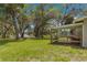 Spacious backyard with lush green grass, mature trees, and lake views, along with a covered enclosure for pets or storage at 3000 Pine Grove Ln, Lady Lake, FL 32159