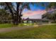 A long private driveway leads to this home with a low-pitched roof, mature trees, and well-manicured lawn at 3000 Pine Grove Ln, Lady Lake, FL 32159