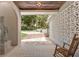 An exterior view of the front porch featuring a statue, patterned concrete blocks, and a rocking chair at 3000 Pine Grove Ln, Lady Lake, FL 32159