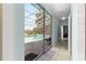 Hallway view featuring a pool patio with a screen enclosure beyond a glass sliding door at 3000 Pine Grove Ln, Lady Lake, FL 32159