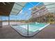 View of in-ground pool featuring a screened enclosure, overhead lighting, and views of the lake at 3000 Pine Grove Ln, Lady Lake, FL 32159